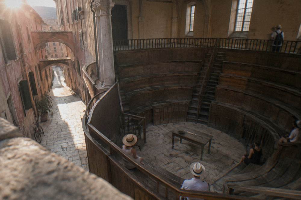 A tiered wooden anatomical theatre with a small central table under a high ceiling