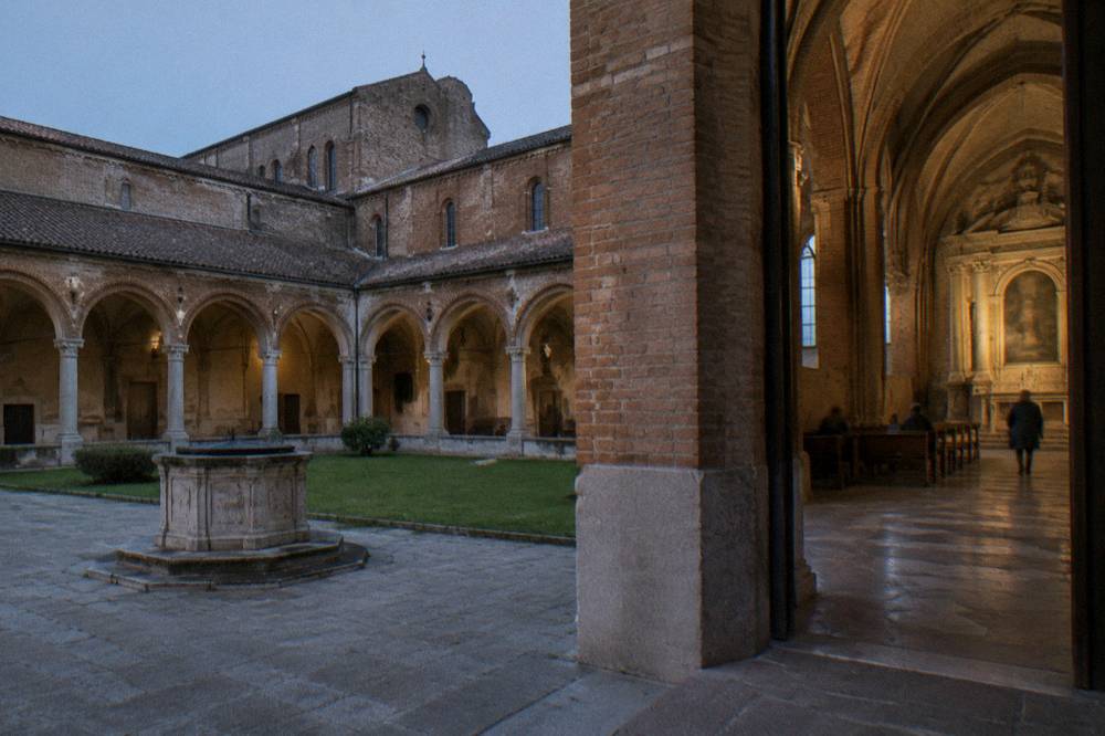 Interior of a large brick basilica with vaulted ceiling and ornate side chapel