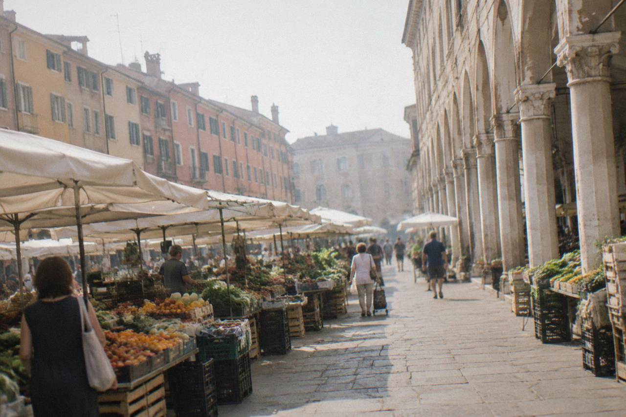Market stalls with fruit and vegetables under the arcades of an Italian square