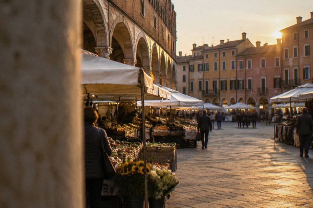 Evening light over market squares and arcades in an old Italian city