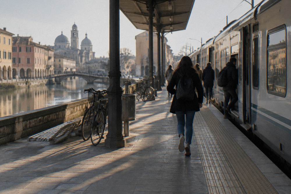 A regional train waiting at a platform of Padua station with passengers boarding