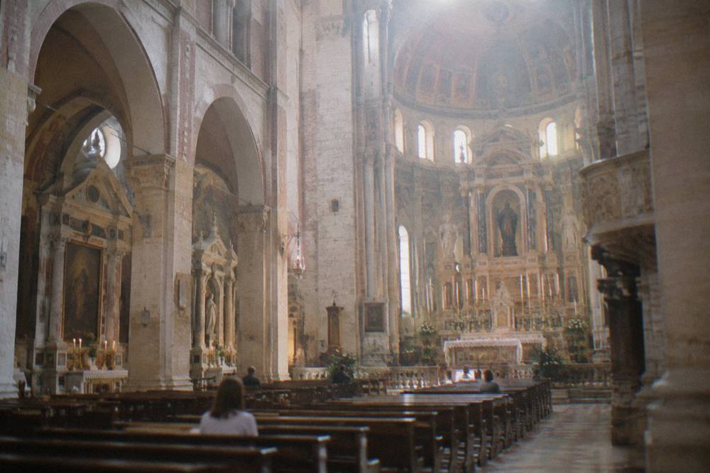 Interior of a large pilgrimage church with an ornate high altar and side chapels