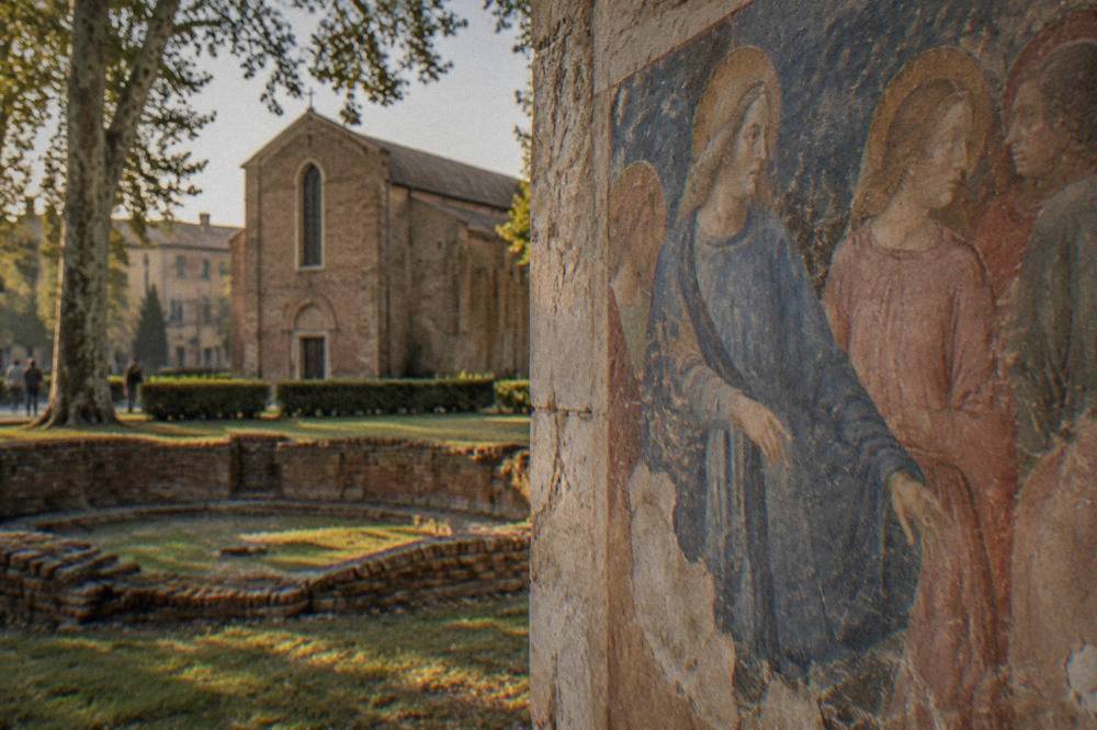 Detail of Giotto frescoes showing figures in blue and pink robes inside the Scrovegni Chapel