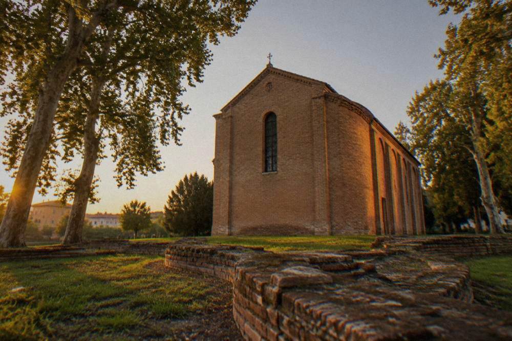 The Scrovegni Chapel exterior at dusk with warm lighting on the brick walls