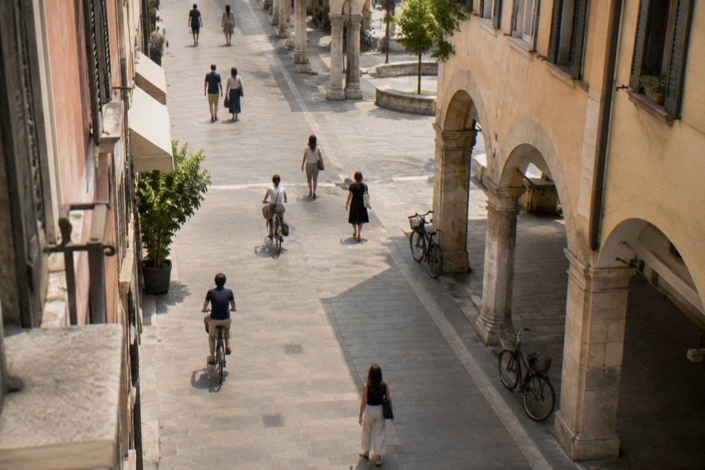 Pedestrian shopping street with porticoes and cyclists in Padua