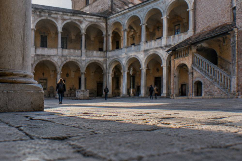 Stone statue of a robed woman in a vaulted university hall