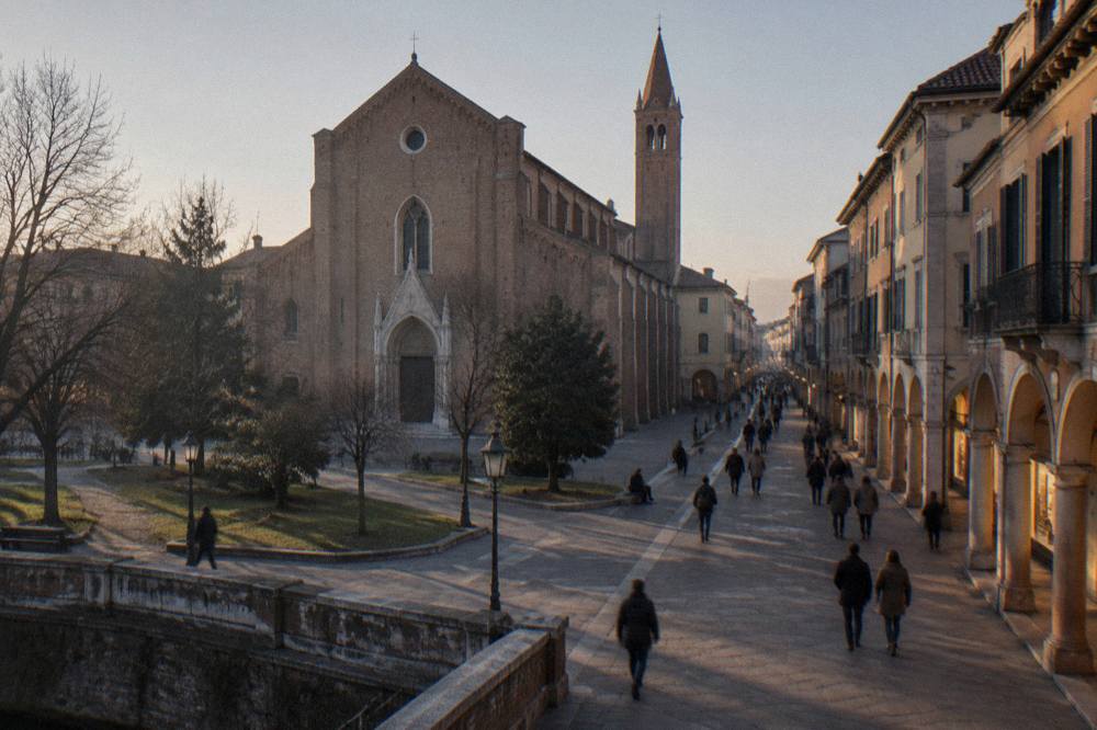 An arcaded Italian street at dusk with lit shopfronts and people strolling