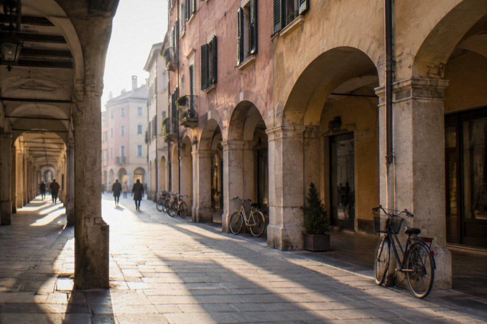 A narrow arcaded shopping street in central Padua with bicycles parked against old walls