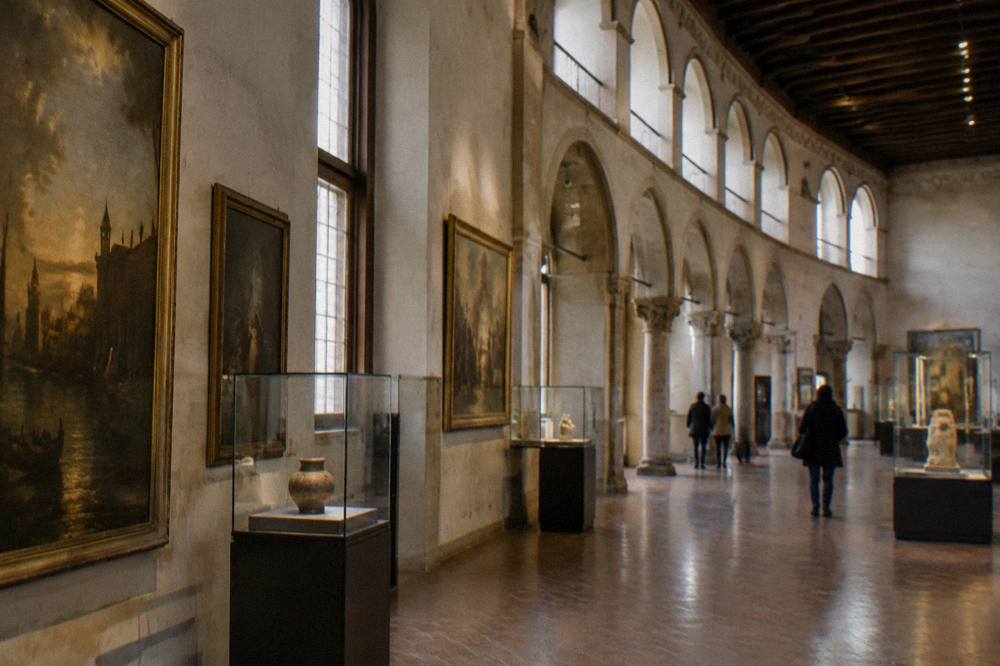 Museum gallery interior with paintings and display cases along the walls