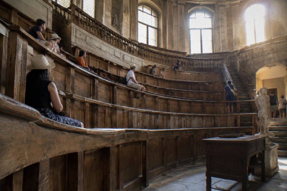 Tiers of carved wooden seats inside a historic anatomical theatre