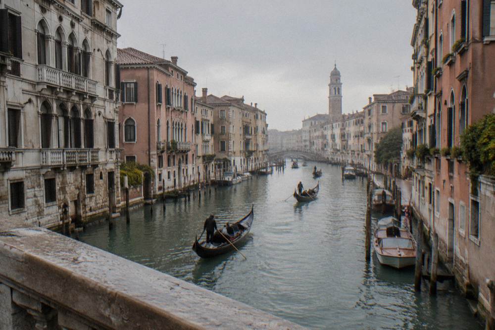 Canal with gondolas and palace facades in Venice seen from a bridge