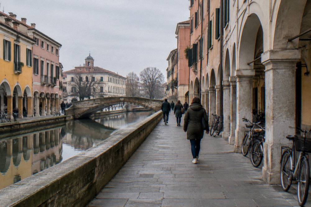 Couple studying a paper map at an outdoor table in a Padua square